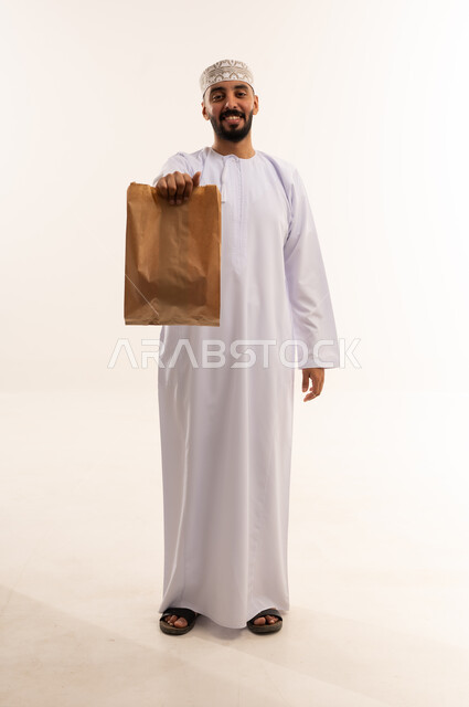 Omani Man Holding Paper Shopping Bag on White Background