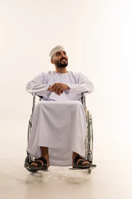 رجل عماني على كرسي متحرك بالزي التقليدي
