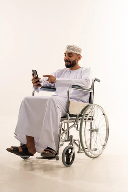 Omani Man in Wheelchair Using Smartphone in Studio