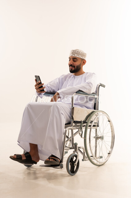 Omani Man in Wheelchair Using Smartphone White Background