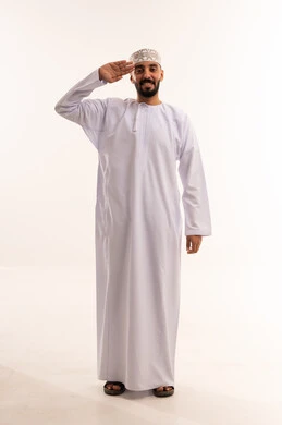 رجل عُماني يؤدي التحية بالزي التقليدي والكمة