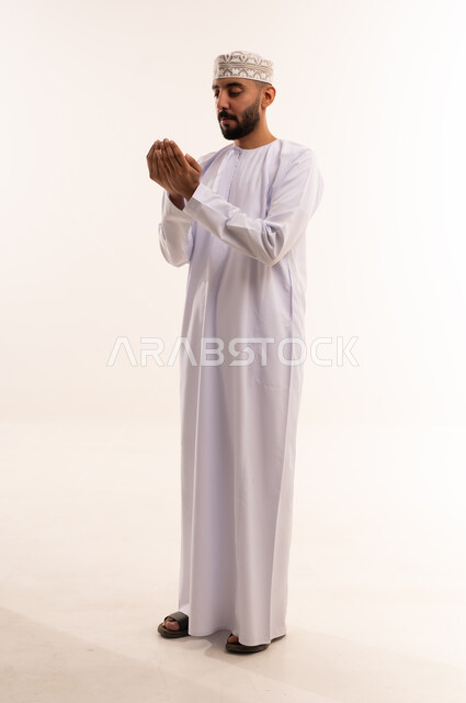 رجل عماني يدعو بالزي التقليدي العماني