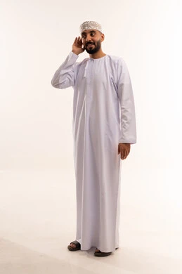 رجل عماني بالزي التقليدي يستمع أمام خلفية بيضاء