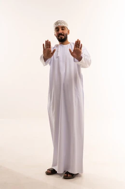 رجل عماني بالزي التقليدي يشير بعلامة التوقف
