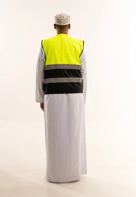 رجل عماني بالزي التقليدي وسترة السلامة من الخلف