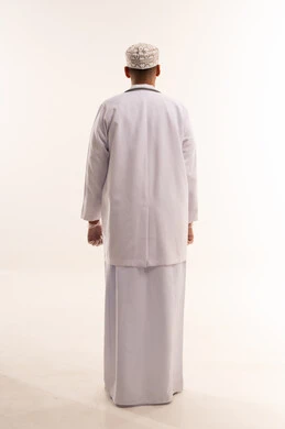 طبيب عماني بالكمة التقليدية والمعطف الطبي من الخلف