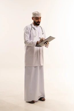 طبيب عماني بالزي التقليدي يكتب على لوحة ملاحظات