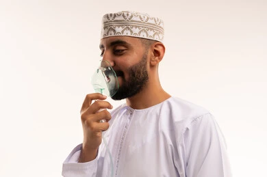 Omani Man Using Medical Nebulizer Mask in Studio