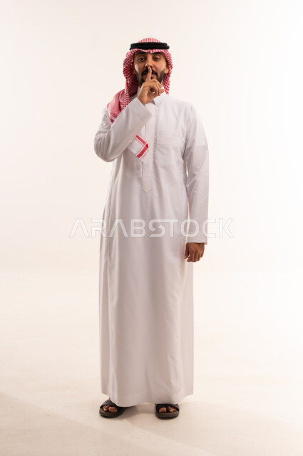 Saudi Man in Traditional Thobe Making Silence Gesture