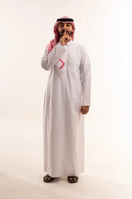 Saudi Man in Traditional Thobe Making Silence Gesture