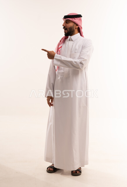 رجل سعودي بالثوب التقليدي يشير بيده جانبا