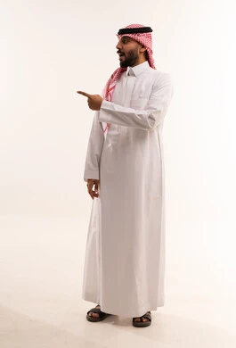 رجل سعودي بالثوب التقليدي يشير بيده جانبا
