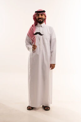 رجل سعودي بالثوب التقليدي يحمل شارباً ورقيًا رجل سعودي بالثوب التقليدي يحمل شارباً ورقيًا