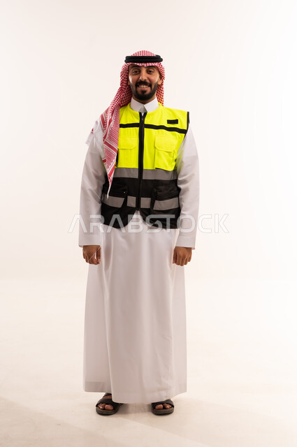 رجل سعودي بالثوب التقليدي وسترة السلامة العاكسة