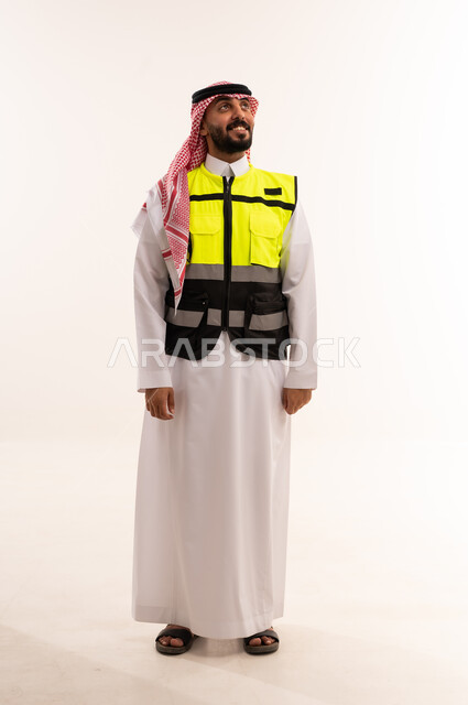 رجل سعودي بالزي التقليدي وسترة السلامة المهنية