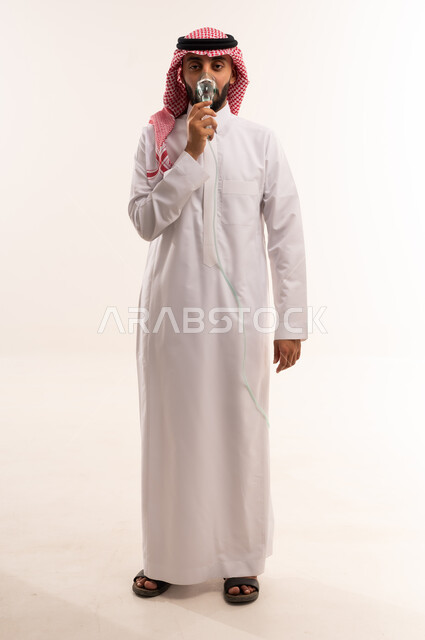رجل سعودي بالثوب التقليدي يحمل مصباحاً كهربائياً