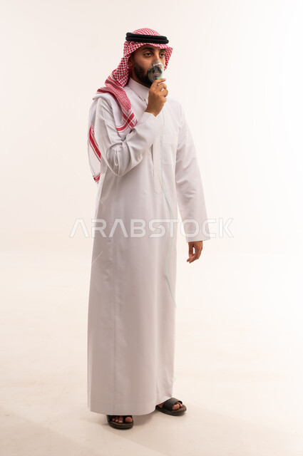 رجل سعودي بالثوب يستخدم بخاخ الربو