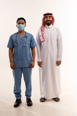 رجل سعودي وممرض آسيوي يقفان على خلفية بيضاء