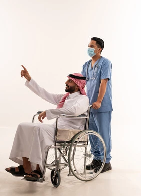 رجل سعودي على كرسي متحرك مع ممرض آسيوي