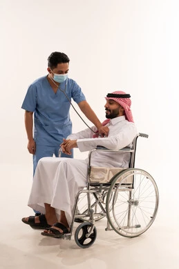 فحص طبي لمريض سعودي يجلس على كرسي متحرك