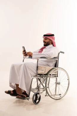رجل سعودي على كرسي متحرك يستخدم الجوال