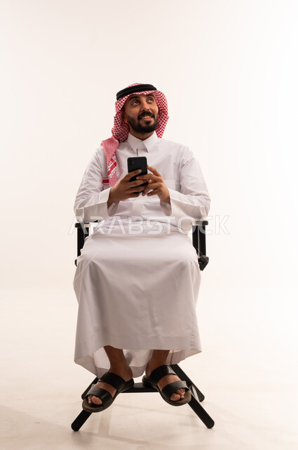 Saudi Man in Traditional Dress Using Smartphone