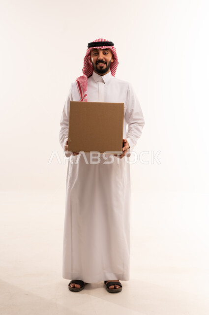 رجل سعودي بالزي التقليدي يحمل صندوق توصيل