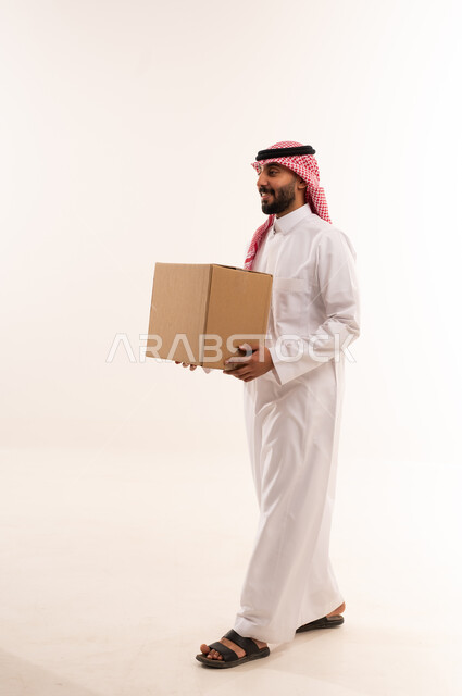 رجل سعودي باللباس التقليدي يحمل صندوق شحن