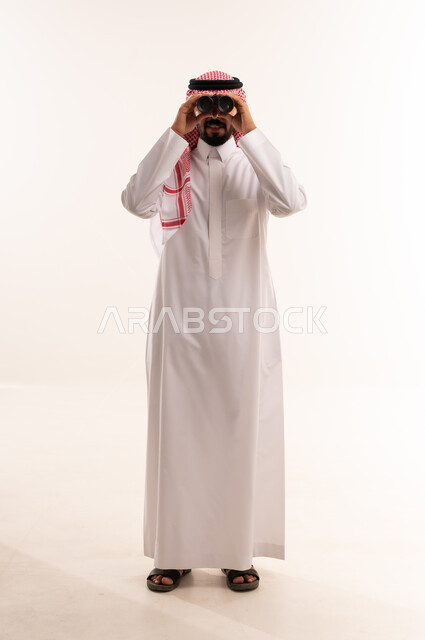 Saudi Man in Traditional Thobe Using Binoculars