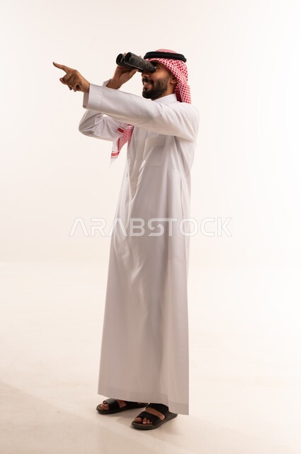 رجل سعودي بالزي التقليدي ينظر عبر المنظار