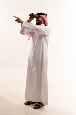 رجل سعودي بالزي التقليدي ينظر عبر المنظار