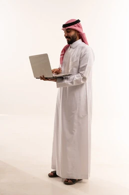 Saudi Man in Traditional Dress Using Laptop White Background