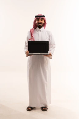 رجل سعودي بالثوب يحمل جهاز حاسوب خلفية بيضاء