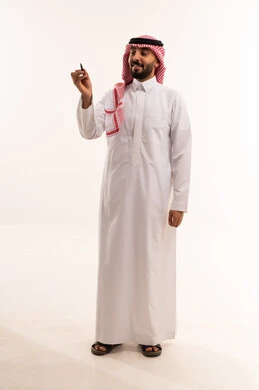 رجل سعودي بالثوب التقليدي يحمل قلماً
