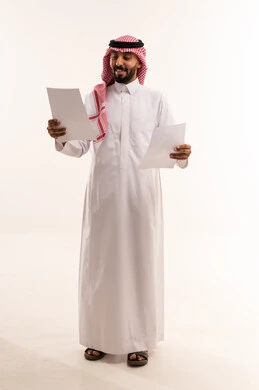 رجل سعودي بالثوب التقليدي يحمل أوراق عمل