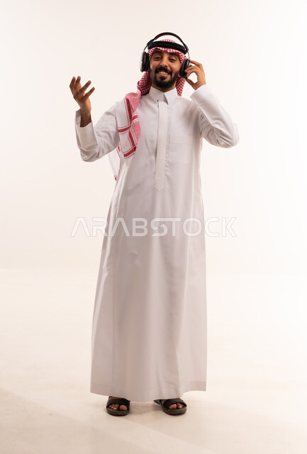 رجل سعودي يرتدي سماعات على خلفية بيضاء