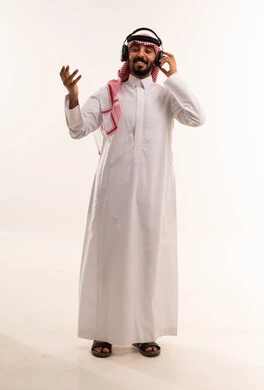 رجل سعودي يرتدي سماعات على خلفية بيضاء