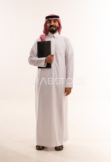 رجل سعودي بالثوب التقليدي يحمل لوحة ملاحظات