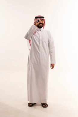 رجل سعودي بالزي التقليدي يستخدم المنظار
