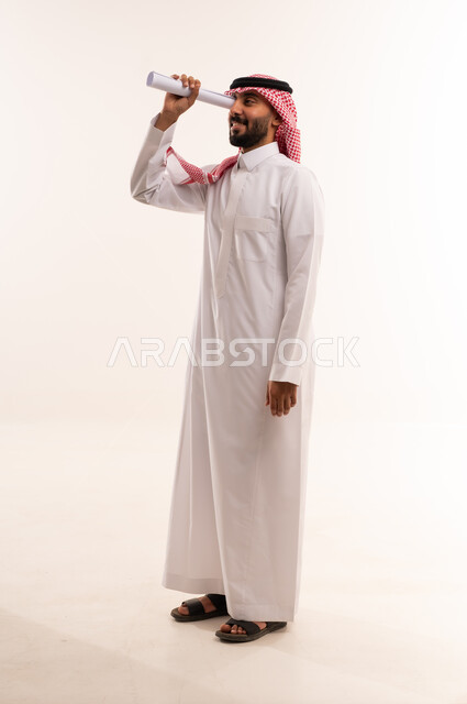 Saudi Man in Thobe Looking Through Paper Telescope