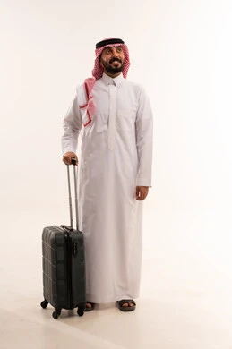 رجل سعودي بالزي التقليدي مع حقيبة سفر