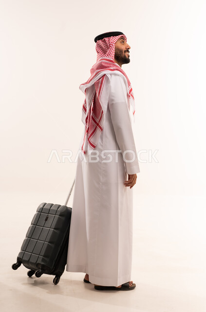 رجل سعودي بالزي التقليدي مع حقيبة سفر
