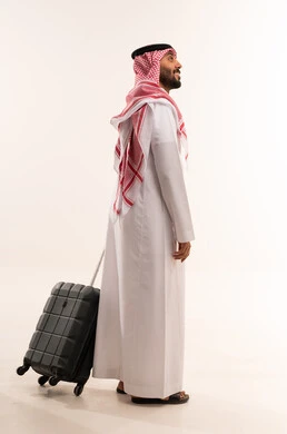 رجل سعودي بالزي التقليدي مع حقيبة سفر
