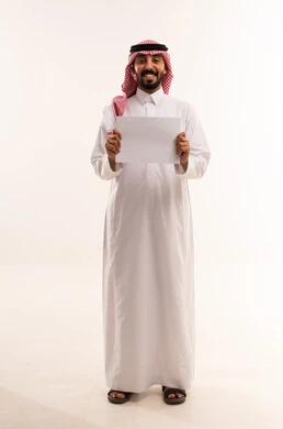 رجل سعودي بالزي التقليدي يحمل ورقة بيضاء فارغة