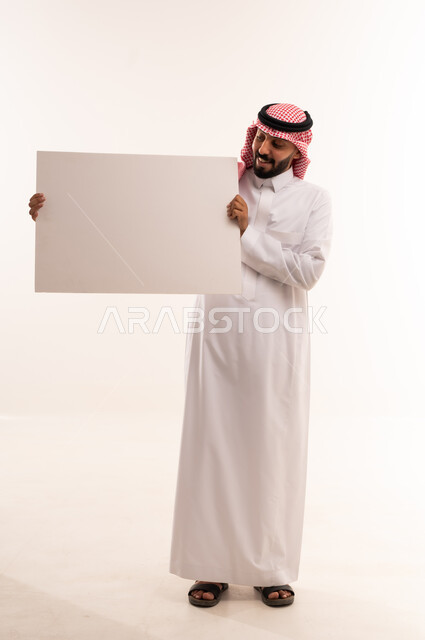 Saudi Man Holding Blank Board in Traditional Thobe