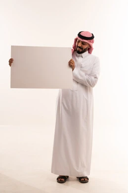 رجل سعودي بالثوب التقليدي يحمل لوحة بيضاء فارغة
