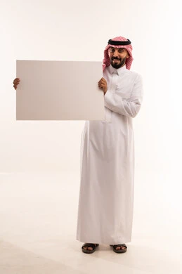 رجل سعودي بالزي التقليدي يحمل لوحة إعلانية بيضاء فارغة