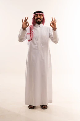 رجل سعودي بالزي التقليدي يشير بعلامة الرضا
