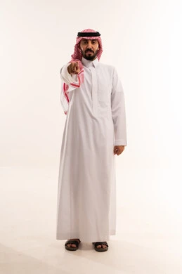رجل سعودي بالزي التقليدي يشير بإصبعه للكاميرا