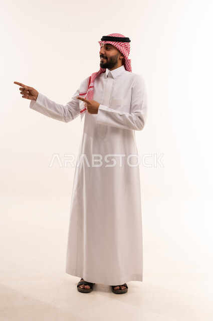 رجل سعودي يشير بيديه بالثوب والشماغ التقليدي